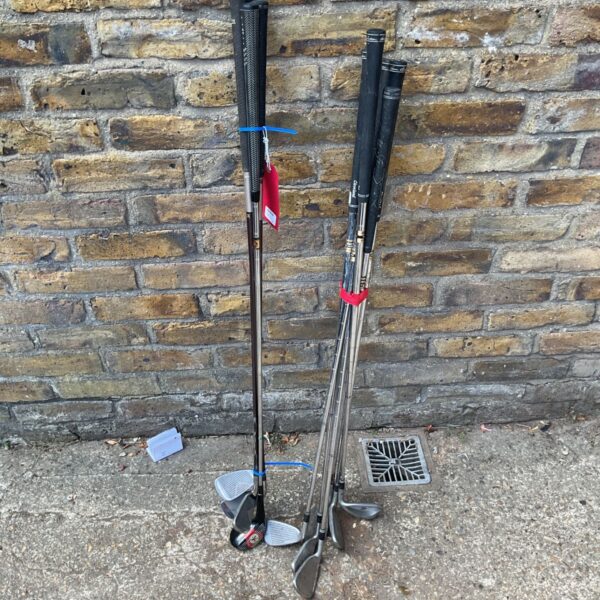 A set of used golf clubs including irons and wedges.
