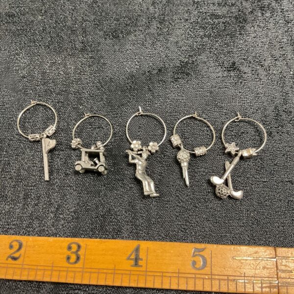 Set of five pairs of golf hoop earrings on a white surface.
