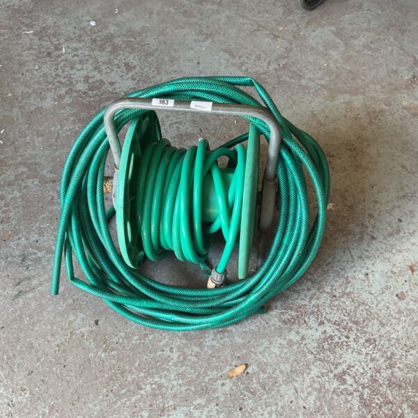 Freestanding green garden hose reel for outdoor use.