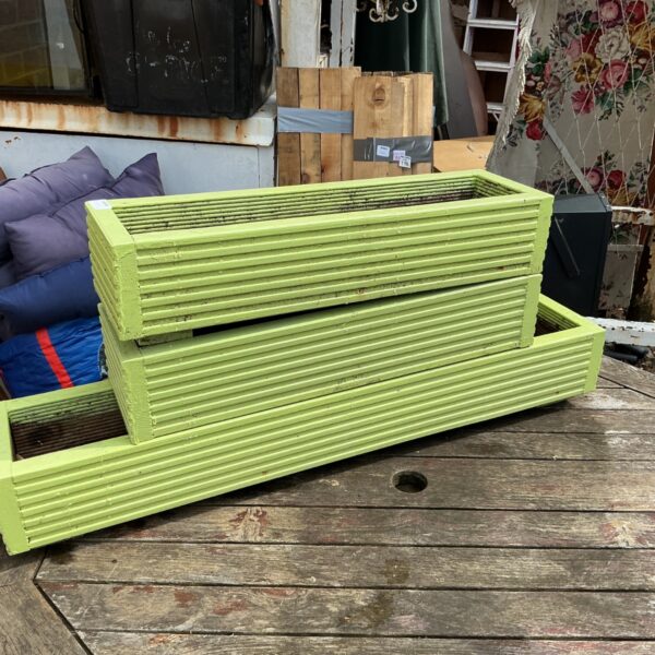 Three green wooden window boxes for garden plants and flowers.