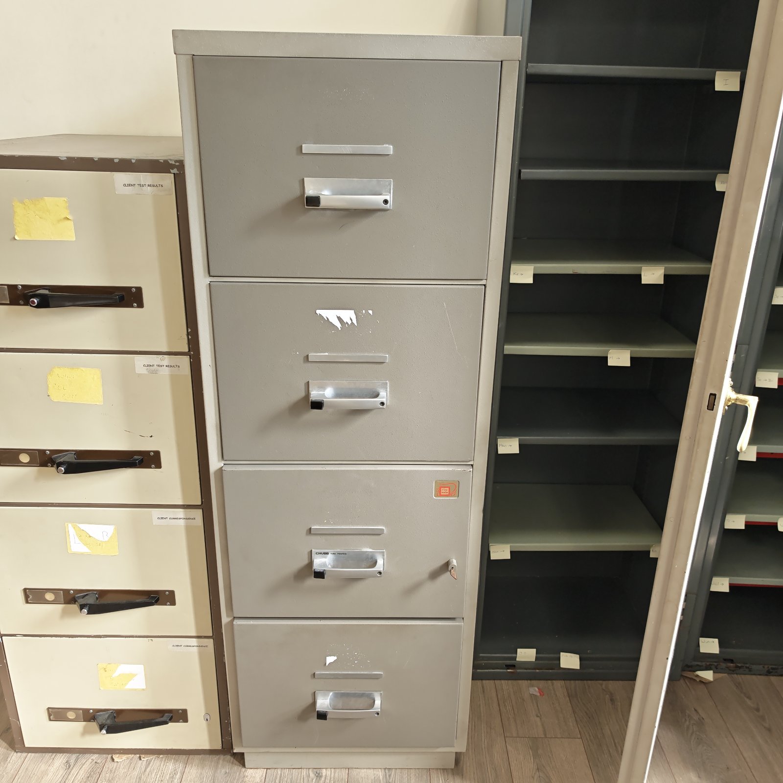 Vintage grey metal four drawer filing cabinet for office storage.