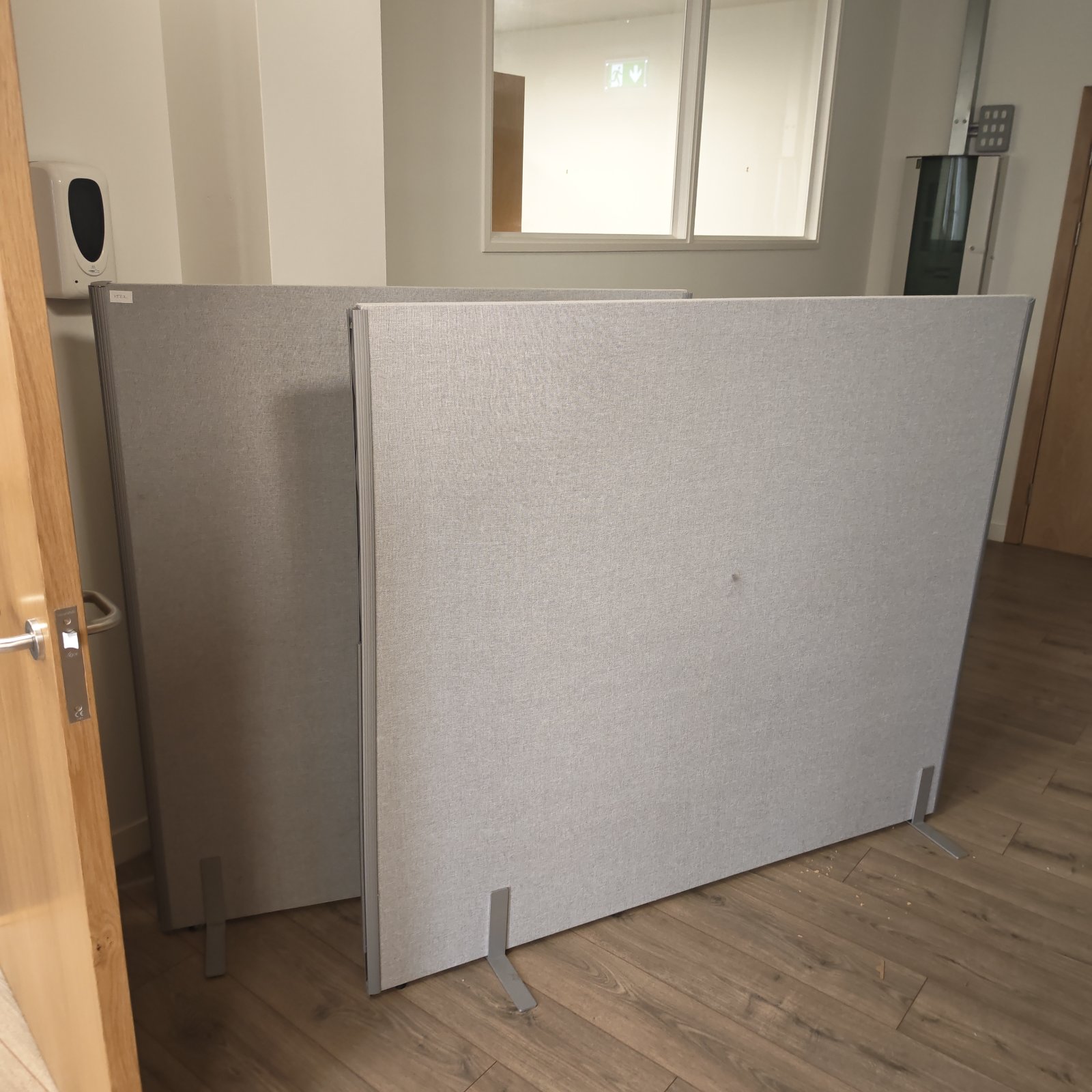 Two grey office privacy screens for workspace division.