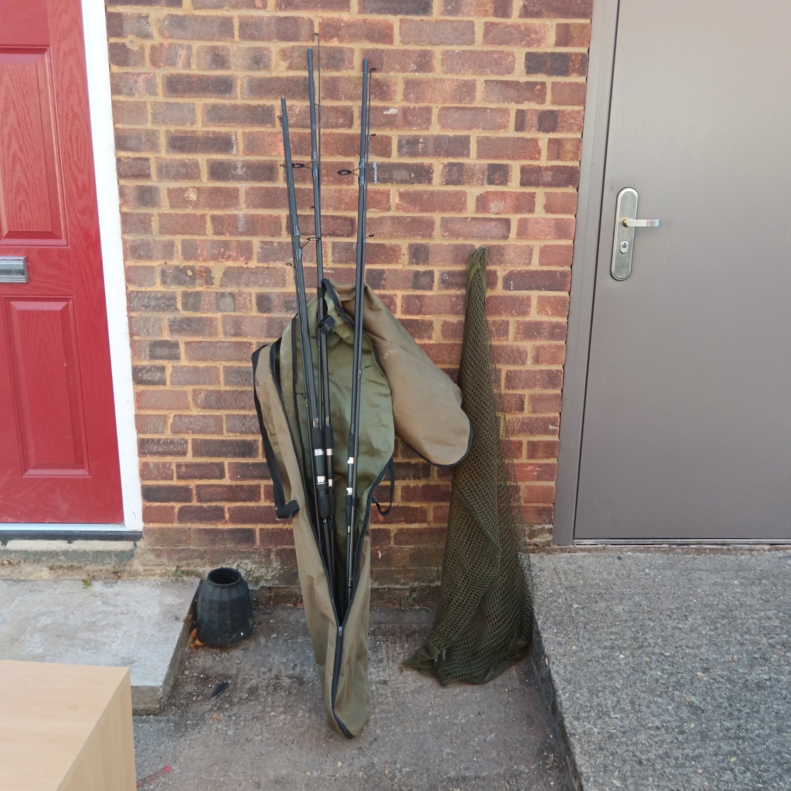 Three Gtech carp fishing rods in a bag with a landing net.