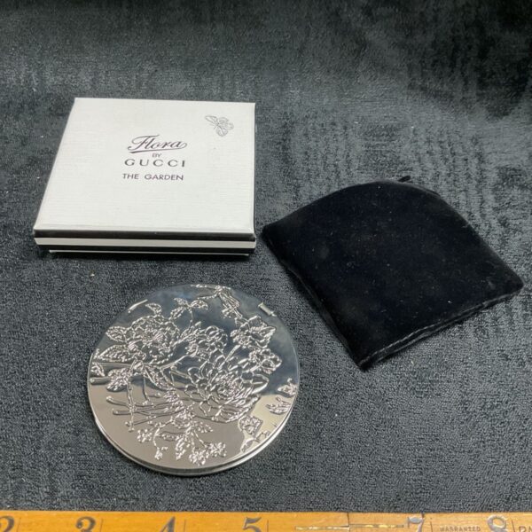 Vintage Gucci Flora compact mirror with floral decoration.