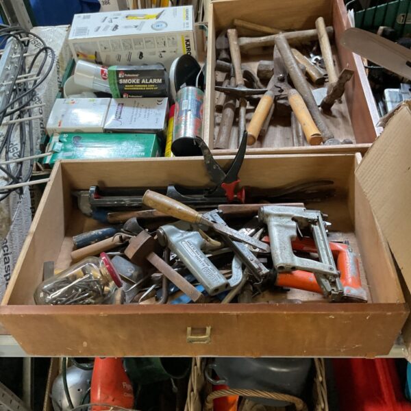 Box of mixed hardware tools including nail guns and chisels.