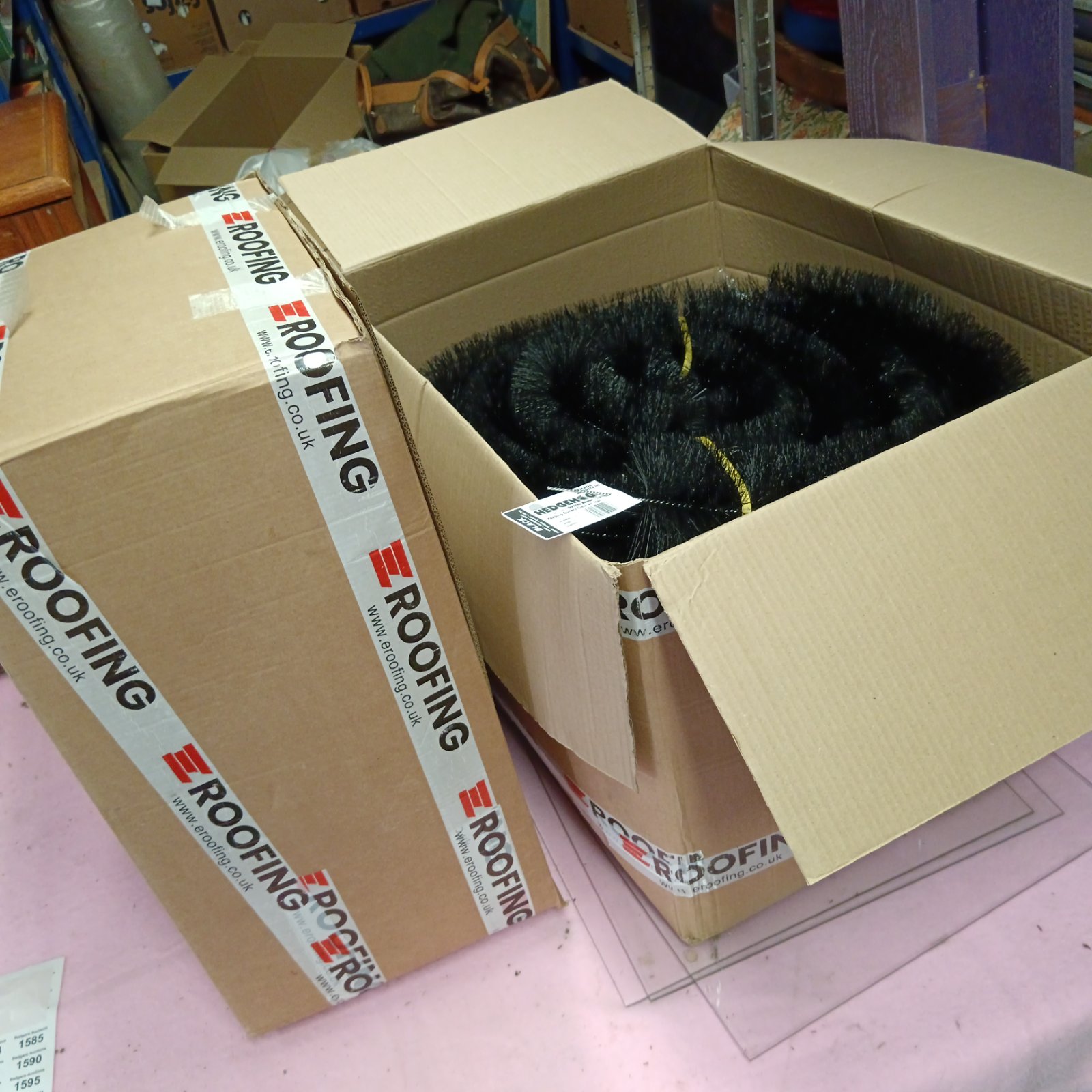 Two boxes of new hedgehog gutter brushes for gutter cleaning.
