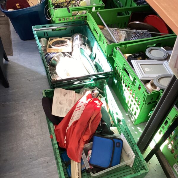 Assorted house clearance items in green storage crates.