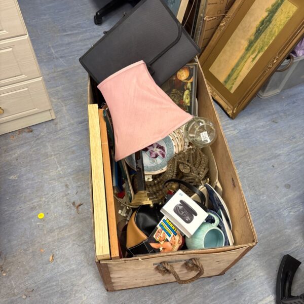 Wooden crate filled with a house clearance lot of mixed household items.