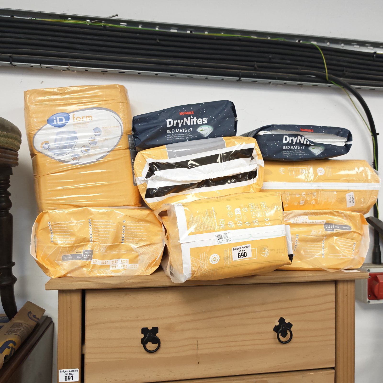 Sealed packs of Huggies DryNites and iD Form bed pads for protection.