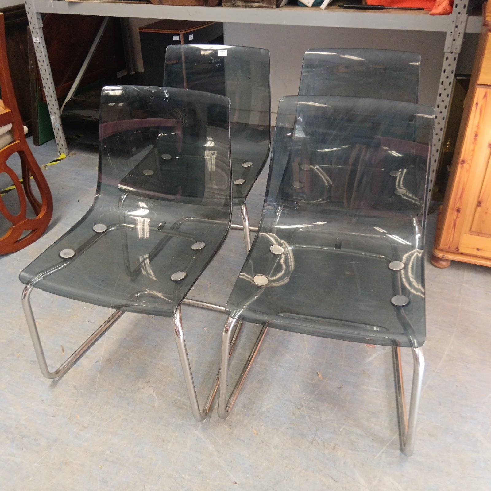 Set of four dark grey IKEA perspex chairs with chrome legs.