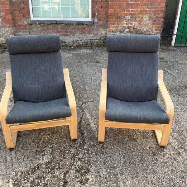 Pair of grey IKEA POÄNG armchairs with birch frames.