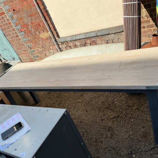 Industrial dining table with light wood and dark metal legs.