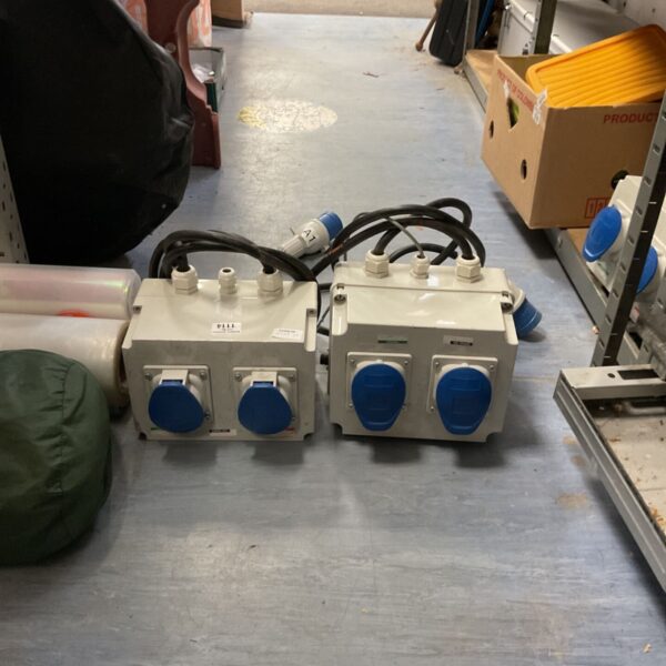 Pair of portable industrial power distribution boxes with blue connectors.