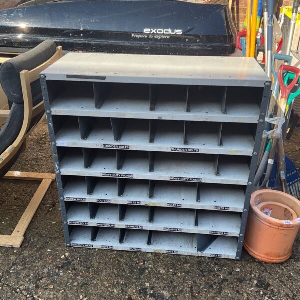 Metal industrial storage unit with multiple compartments for parts.