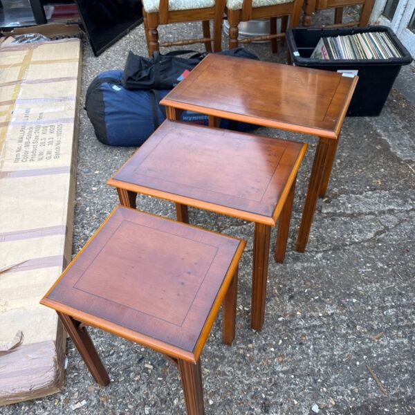 Vintage inlaid wooden nest of tables in a cluttered setting.