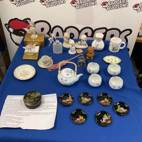 Vintage Japanese black lacquered coasters and fine china bowls on display.
