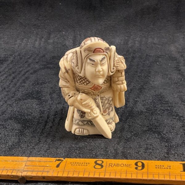 Detailed Japanese warrior figurine, carved bone or resin sculpture.