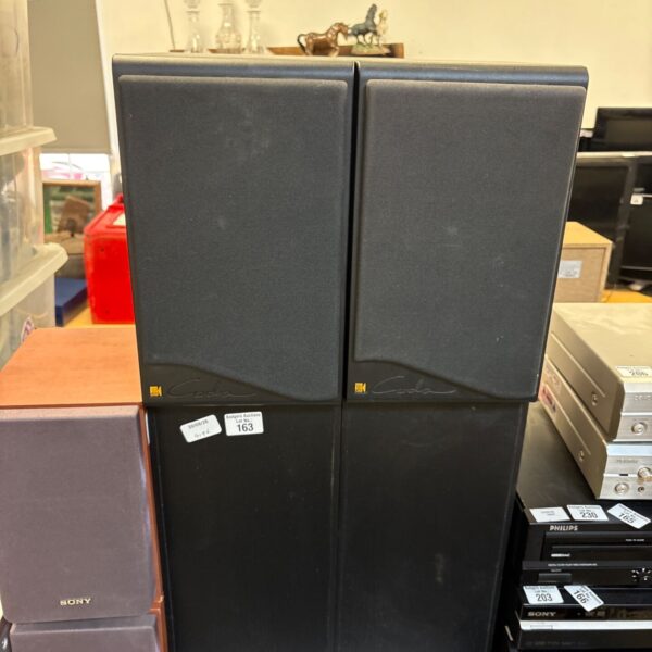 Pair of vintage KEF Carla speakers in a cluttered room.