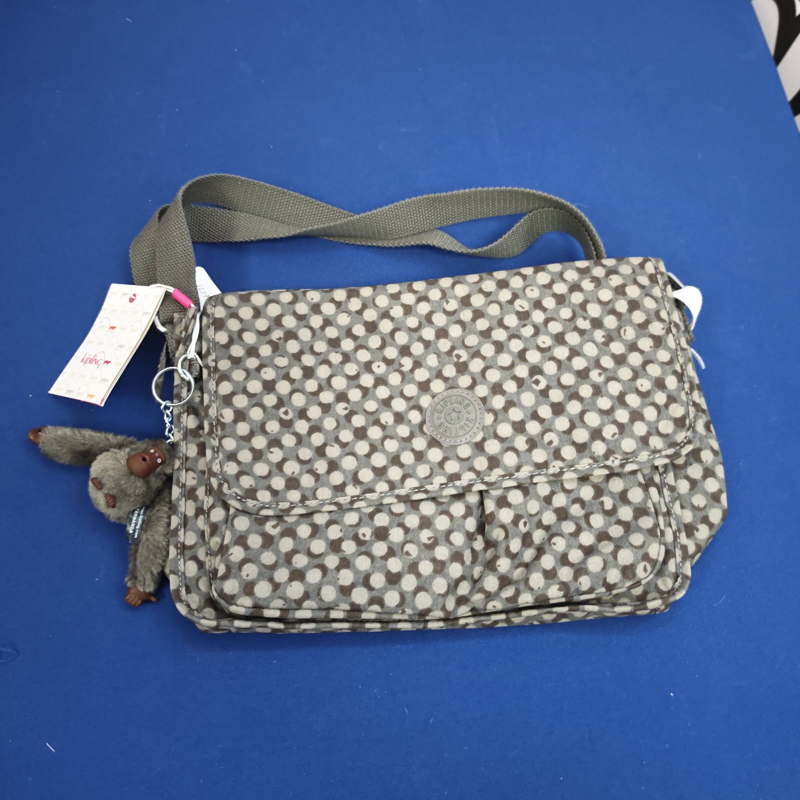 Unused Kipling shoulder bag with patterned fabric and monkey charm.