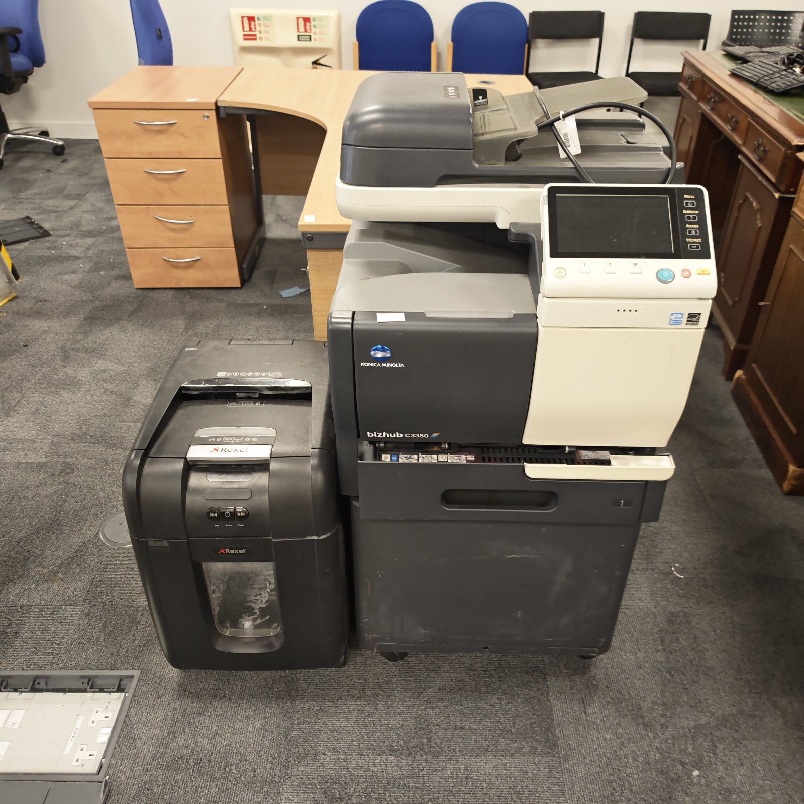 Konica Minolta Bizhub C350 printer and Rexel paper shredder in an office setting.