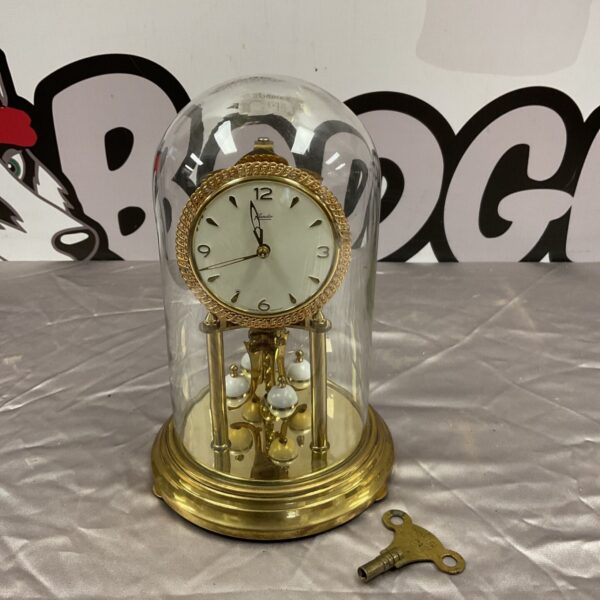 Vintage Kundo anniversary clock with glass dome and brass case.