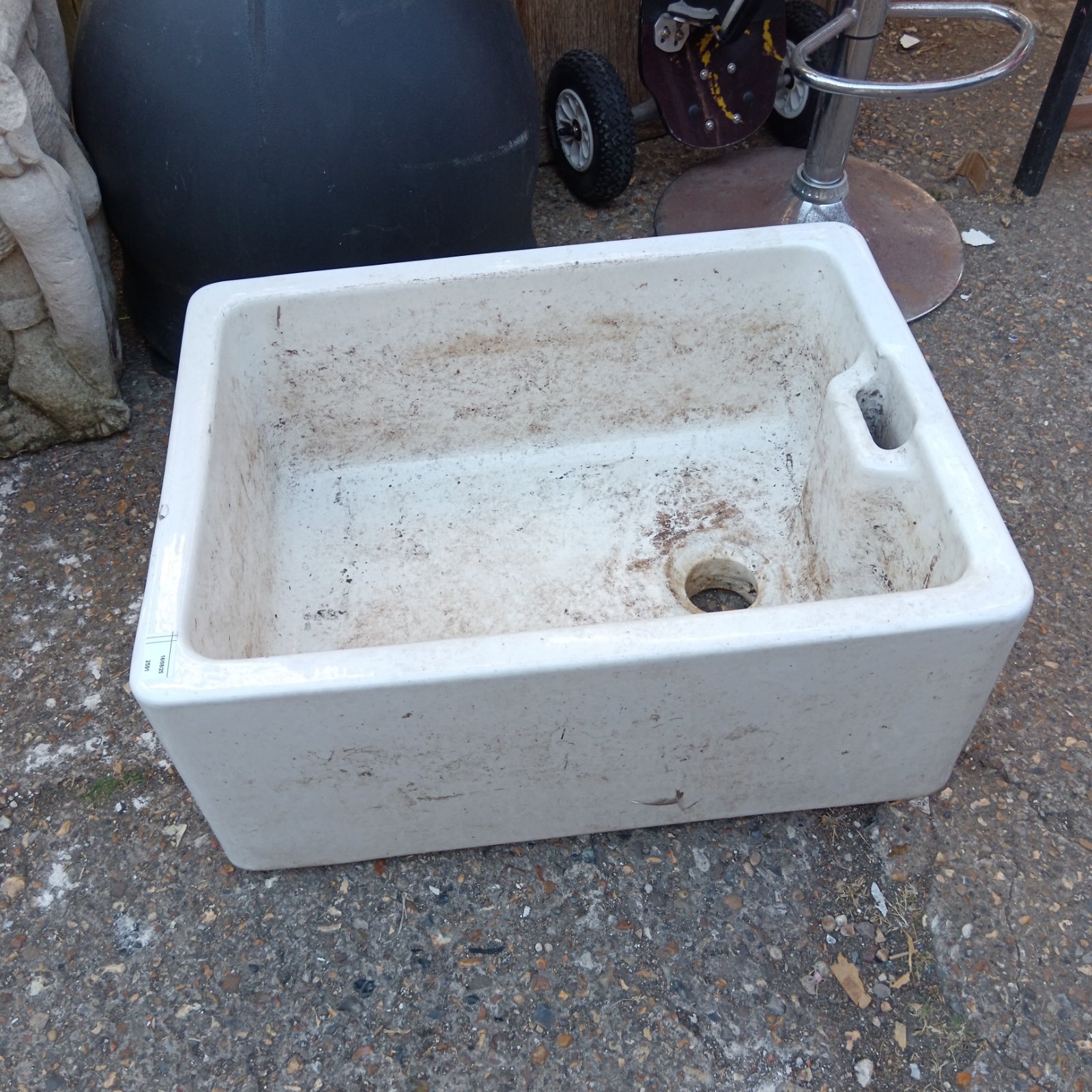 Large ceramic Belfast sink with a worn patina.