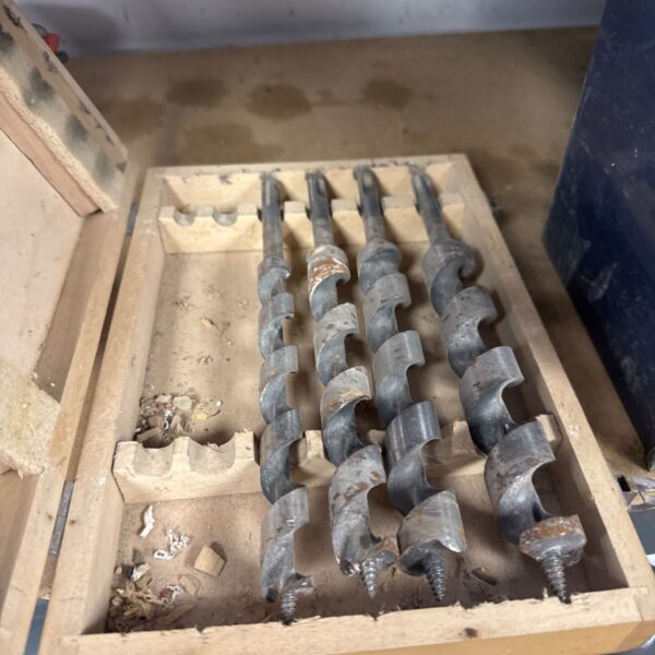 Vintage large drill bits in a wooden storage box.