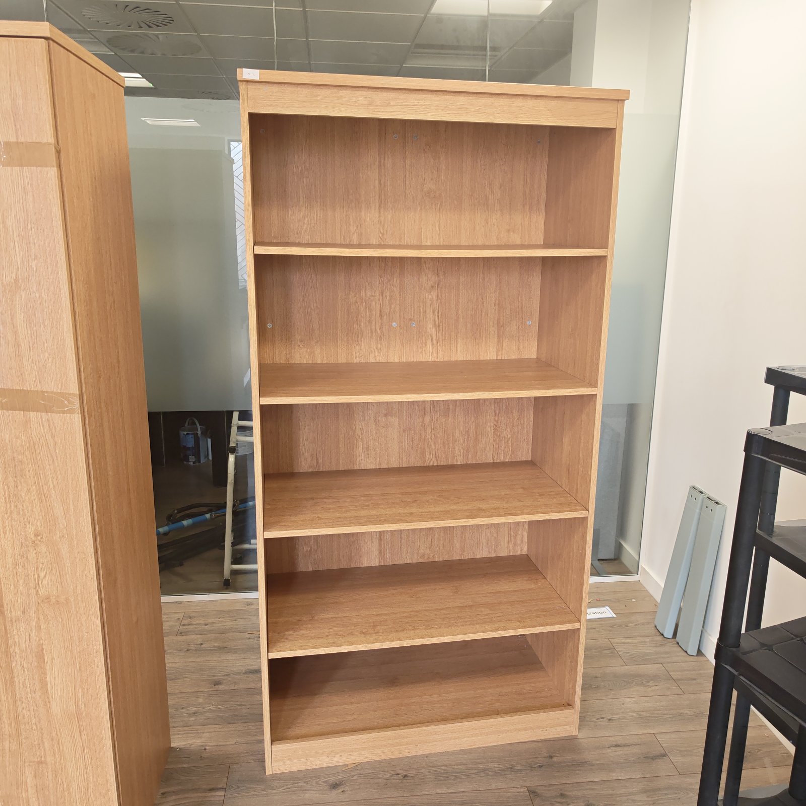 Large wooden office bookcase with multiple shelves for storage.