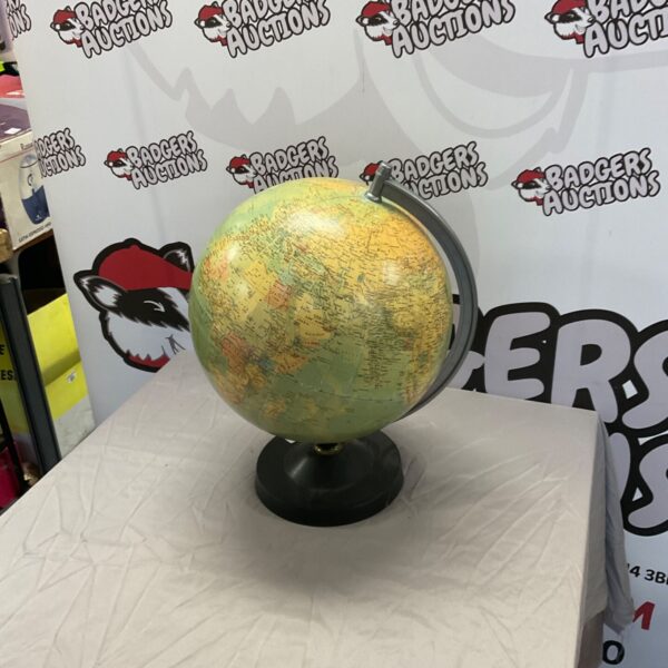 Large vintage globe with detailed world map on a dark base.