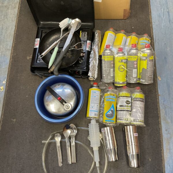 Box of camping equipment inc gas cooker with twelve butane gas cylinders ,kettle ,frying pan ,cutlery ect