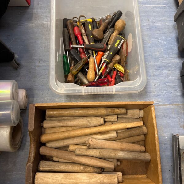 tub of mixed tools with a tray of wooden handles