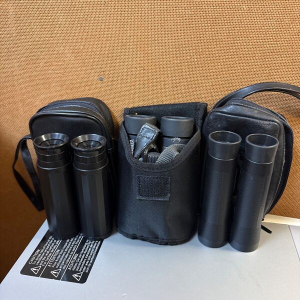Three sets of binoculars in cases