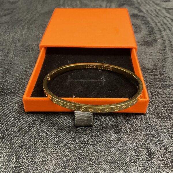 Gold tone Louis Vuitton style hinged bracelet with box.