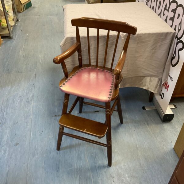 Antique mahogany child’s high chair with padded seat and spindle back.