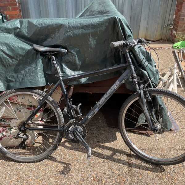 Side view of a used Marin mountain bike with worn tires.