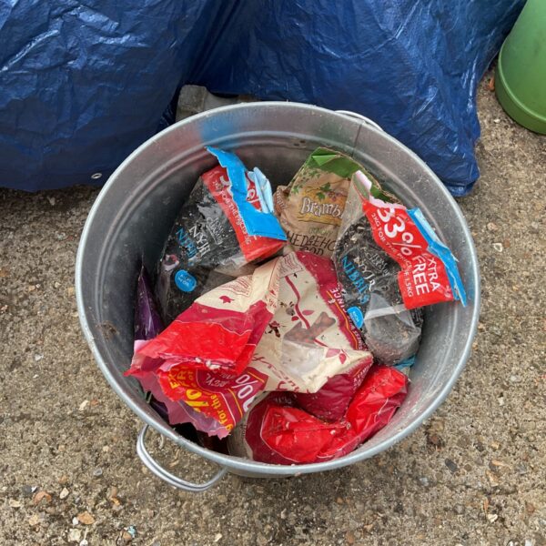 Full metal bin containing mixed animal food and bird seed.