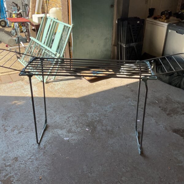 Black metal clothes airer for indoor laundry drying.