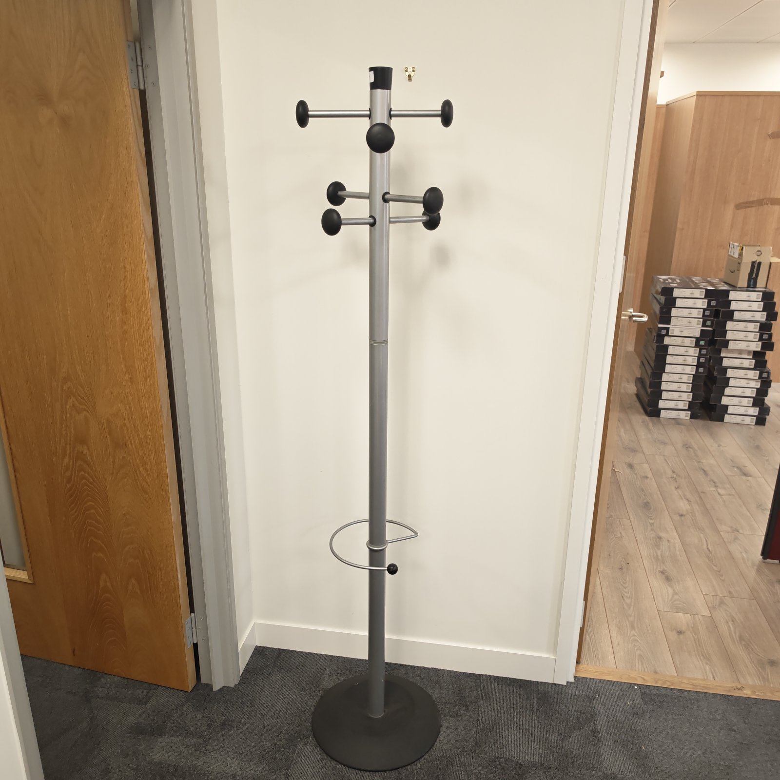 Metal coat and umbrella stand in a hallway setting.