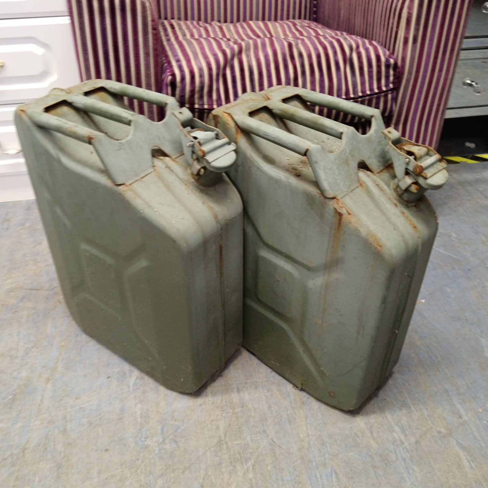 Pair of vintage military jerry cans showing wear and rust.