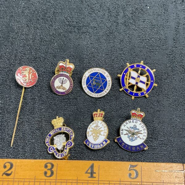 Collection of vintage military pin badges, including HM Armed Forces veteran badges.