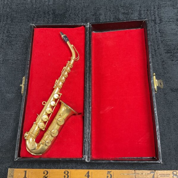 Detailed miniature brass saxophone, a collectible musical instrument.
