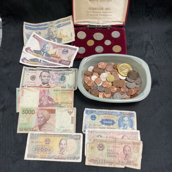 Mixed currency lot with Indonesian Rupiah banknotes and coins on a tray.