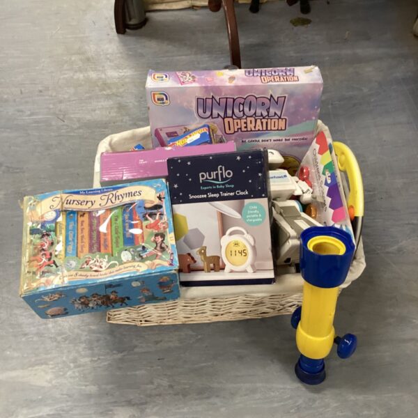 Wicker basket filled with vintage toys and games, including Unicorn Operation.