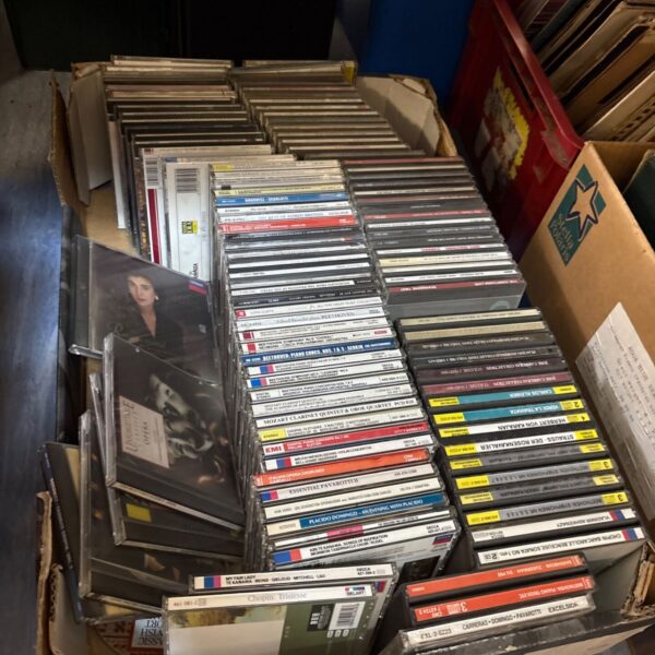 Crate filled with a large lot of mixed music CDs.