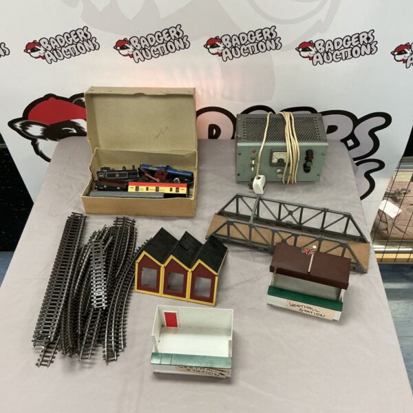 Box of vintage model railway set with trains and accessories.