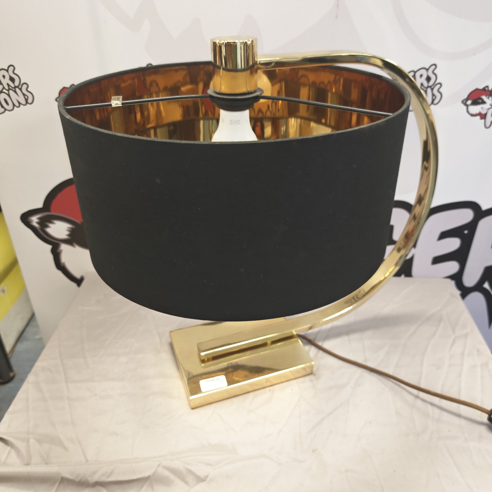 Modern brass effect table lamp with curved shade.