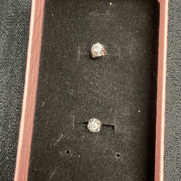 Pair of sparkling moissanite stud earrings on a display card.