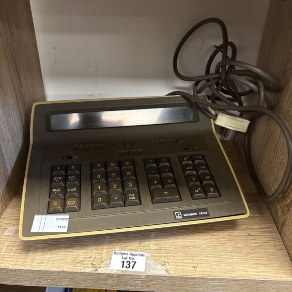Vintage Monroe 1930 electronic calculator on a wooden surface.