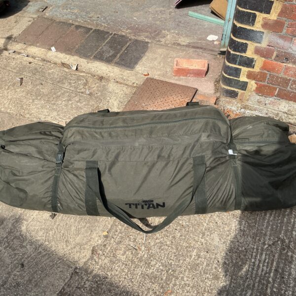 Used Nash Titan carp fishing bivvy in green, showing signs of wear.