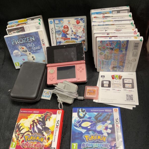Pink Nintendo 3DS console with Pokemon games and accessories.